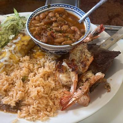 Mexican combination platter featuring shrimp, steak, rice and beans.
