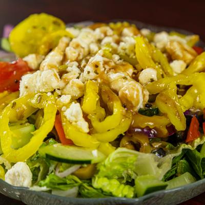 Mixed salad with lettuce, banana peppers, feta cheese, and olives.