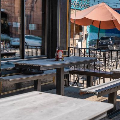 Outdoor seating with picnic tables and a sun umbrella.
