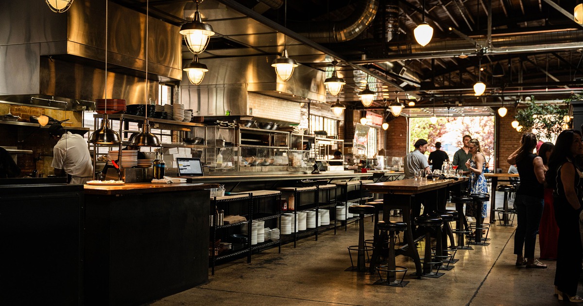 A modern, stylish, and cozy restaurant interior with an open kitchen concept