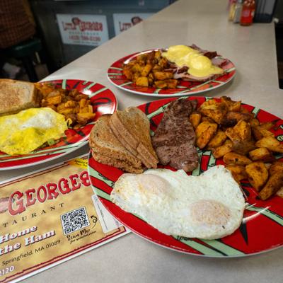 Various breakfast plates with eggs, potatoes and toast.