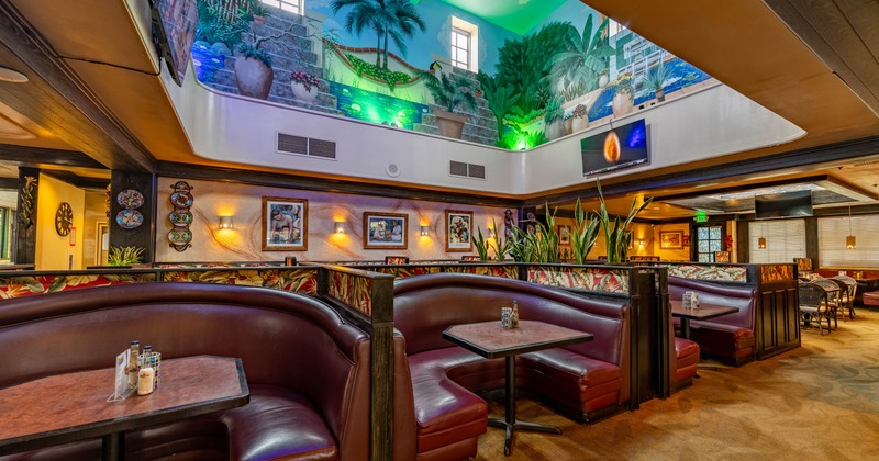 Interior, dining area, ''U'' shaped seating booths, high ceiling with tropical motif murals