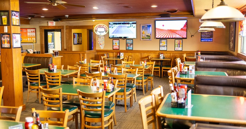 Diner area, tables and chairs, tv's above