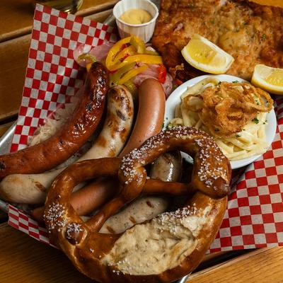 Pretzel, sausages, breaded pork cutlet, sauerkraut, pickles, and mustard.