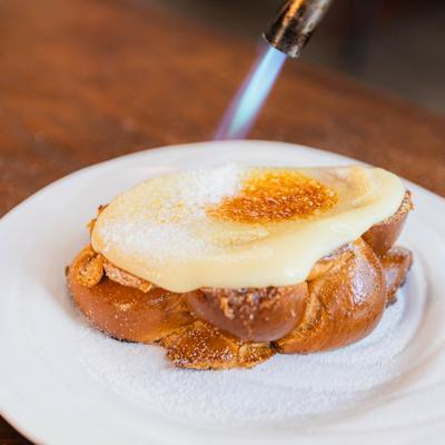 French toast featuring a custard topping  being caramelized with a kitchen torch.