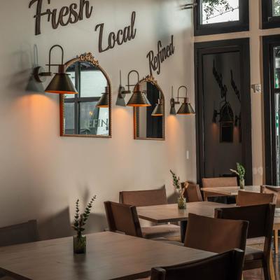 Dining area with mirrors, lamps and wooden tables.