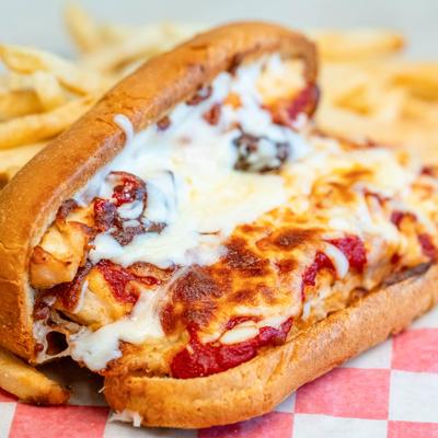 Chicken parmesan sandwich with side fries.