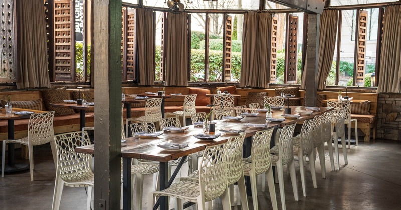 Interior, dining area, long table setup for sixteen people, seating area in the back