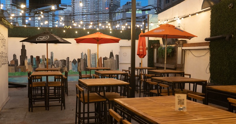 Exterior, high seating area, tables with stools with and without parasols, concrete flooring