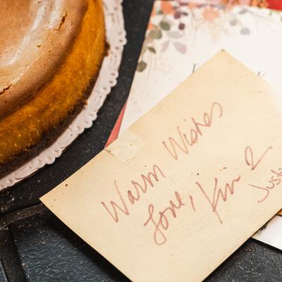 A gift tag, placed next to a cake.