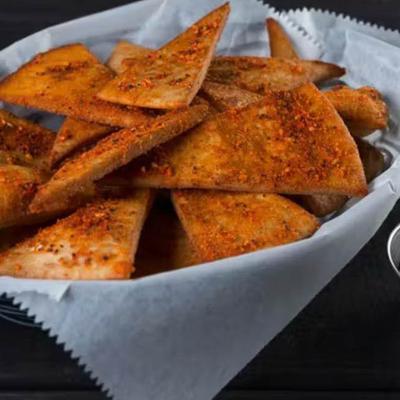 Snackers wedges served in a paper-lined basket with a side of cheese dip.
