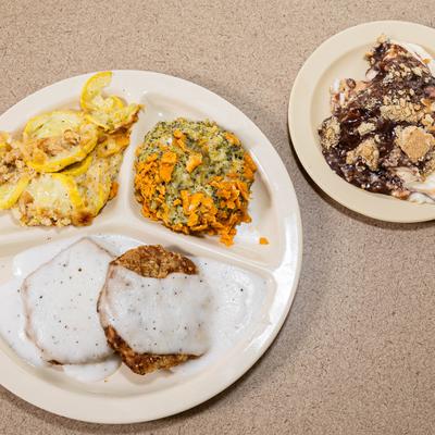Pork chop with gravy, casserole, and potato salad.