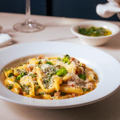 Cavatelli pasta topped with sausage, broccoli florets, and grated Parmesan cheese.