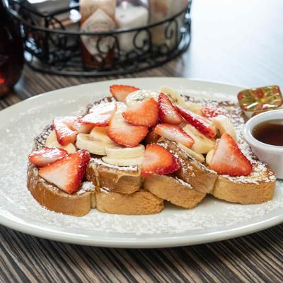 French toast with fresh strawberries, bananas,powdered sugar, and maple syrup