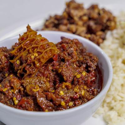 Spicy Ofada sauce with white rice and fried plantains photo