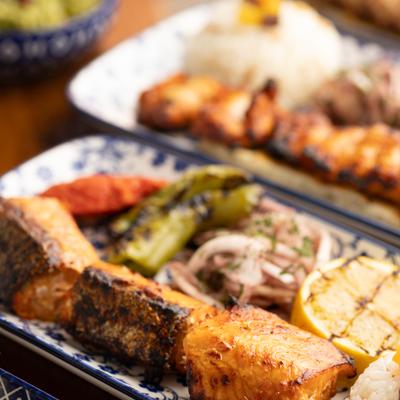 Salmon Kebab served with sides and garnishes, close-up.