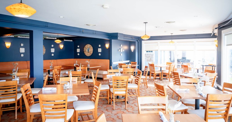 Interior, dining area, wooden top tables with wooden chairs, booths in the back