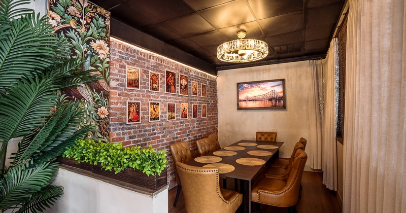 An elegant private dining area with a long wooden dining table and brown leather chairs