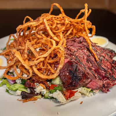 Steak Cobb Salad topped with crispy onion strings.