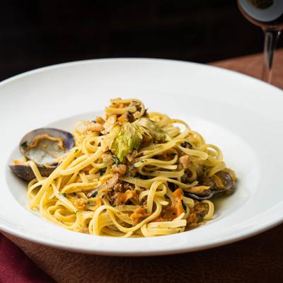 Linguine with clams served on a white plate.