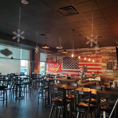 Seating area with pendant lights, snowflake ceiling decorations, and an American flag wall.