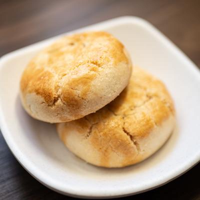 Two Maui Manjookie cookies on a white plate.
