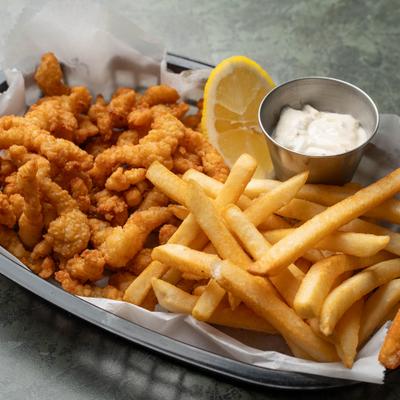 Fried clam strips served with dipping sauce and French fries.
