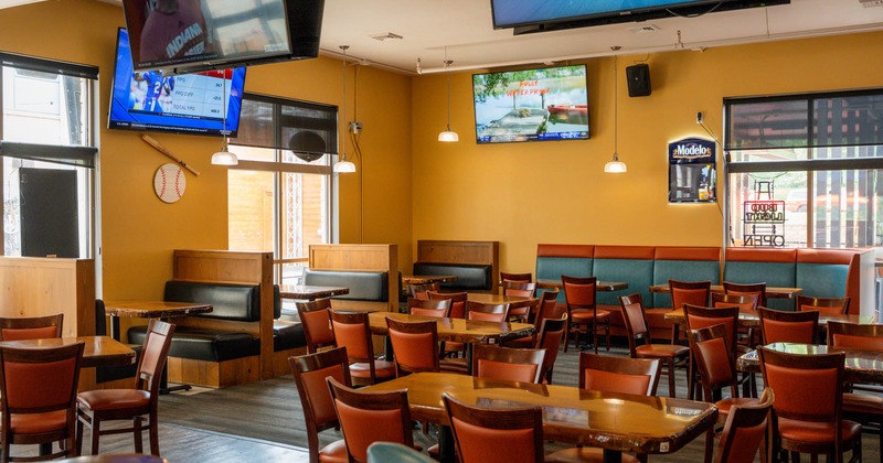 Interior, wide shot of dining area, big TV's on the walls
