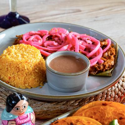 Slow roasted marinated pork, with pickled red onions, rice, and pinto beans.