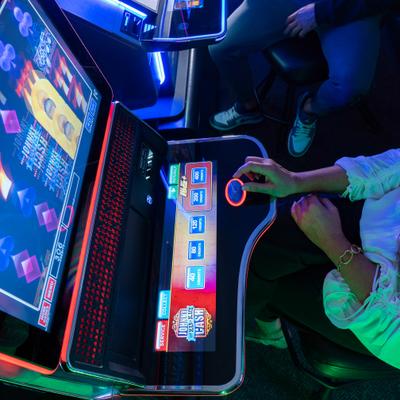 Hand pressing a slot machine button.