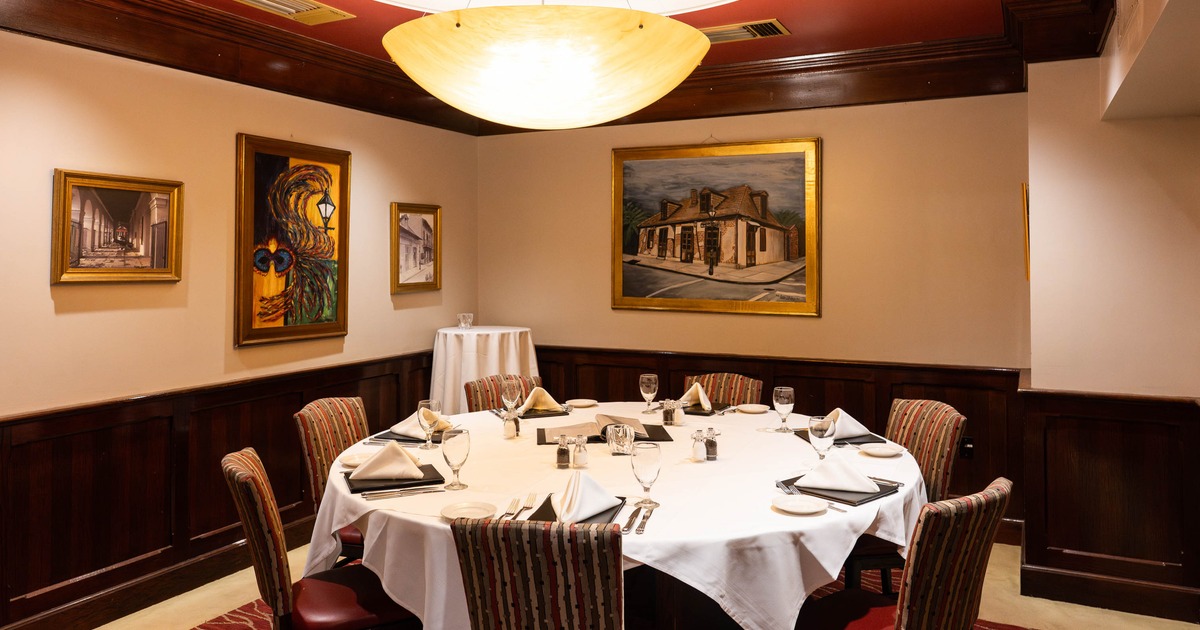 Interior dining room with a round table set for a meal, artworks on the walls