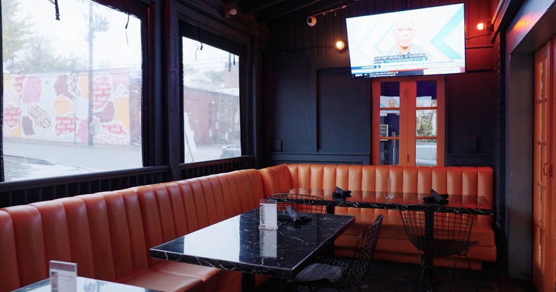 Interior, leather seating with dining tables and chairs, wall TV