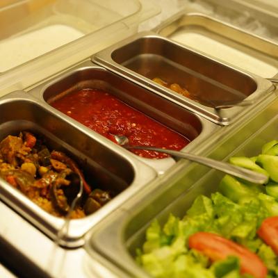A buffet setup with various food items in metal serving trays.