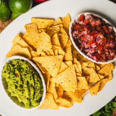 Guacamole and pico de gallo with chips, top view.