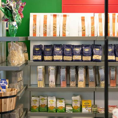 Store shelves display assorted pasta in various packaging.