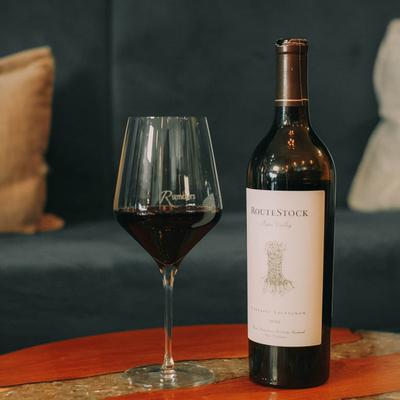 Glass of red wine and a bottle on the table