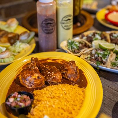 Mole Ranchero served with tacos and cindiments.