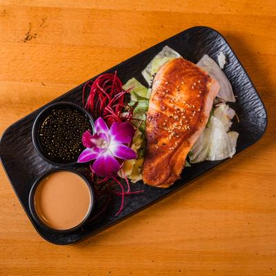 Grilled salmon salad served with two sauces.
