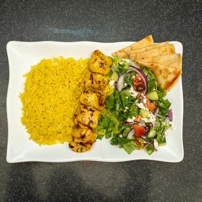 Chicken Kebab Plate  with salad, rice, and pita.