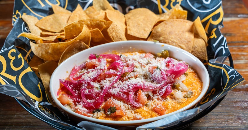 Buffalo dip, topped with pickled red onions, and a side of tortilla chips