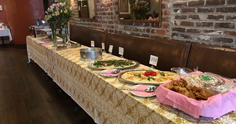 A long table adorned with an array of food and  floral display