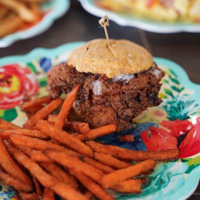 Fried chicken biscuit sandwich with sweet heat mustard sauce, served with sweet potato fries.