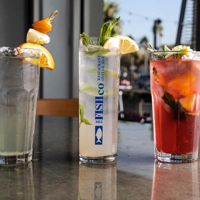 Three cocktails lined up on a reflective surface