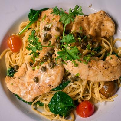 Pan fried chicken with capers, spinach, tomatoes, parsley, and linguine.