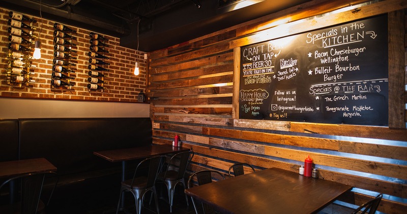 Seating area, wall wine racks on one wall, and chalkboard signage on the other wall