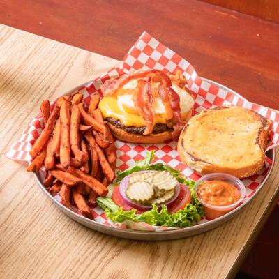 Bacon cheeseburger with fried egg, chipotle mayo, and sweet potato fries.