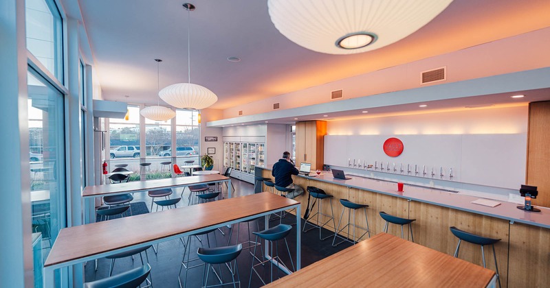 Interior, bar on the left, high seating tables with bar stools, large lanterns
