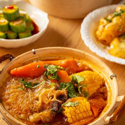 Slow-Braised Tomato Oxtail Soup with vermicelli rice noodles, corn, and carrots.