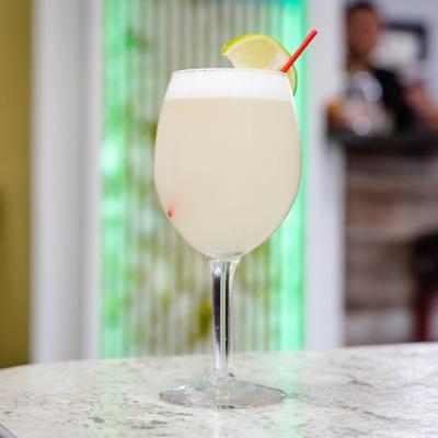 Pisco Sour garnished with a lime wedge.
