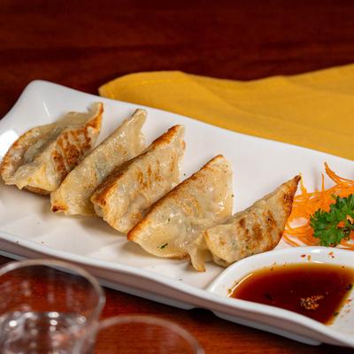 Gyoza dumplings served with a dipping sauce.